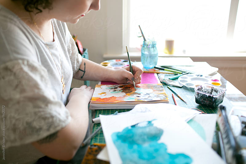 Artist creating colorful art on messy table