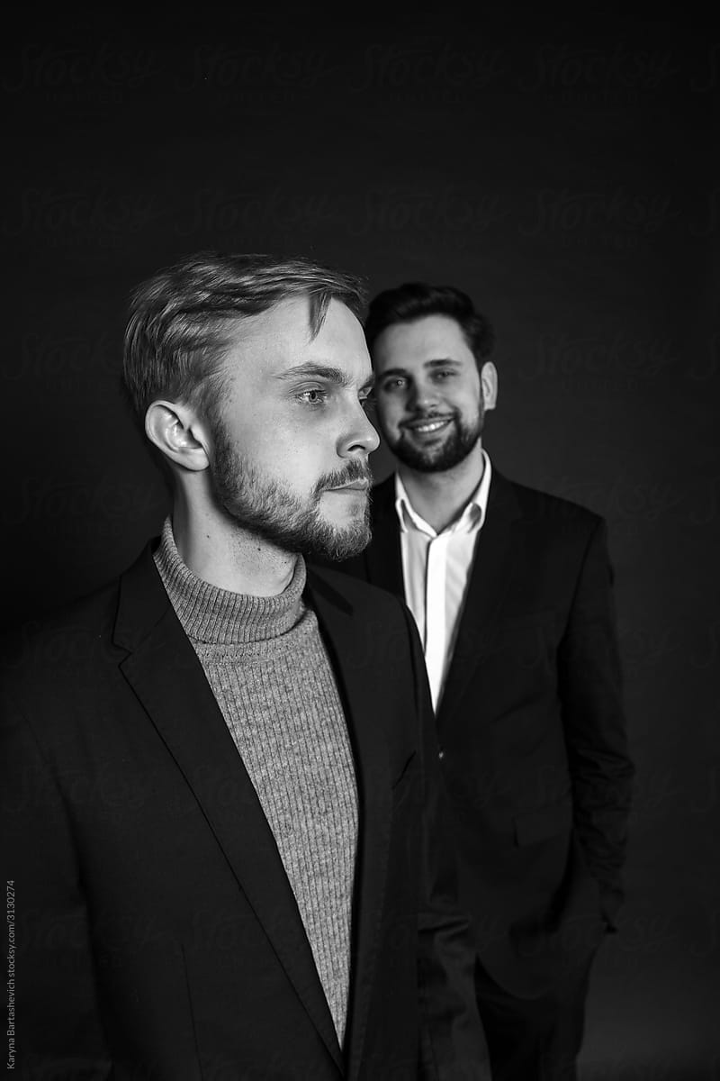 black and white portrait of guys in studio in stylish suits smiling posing