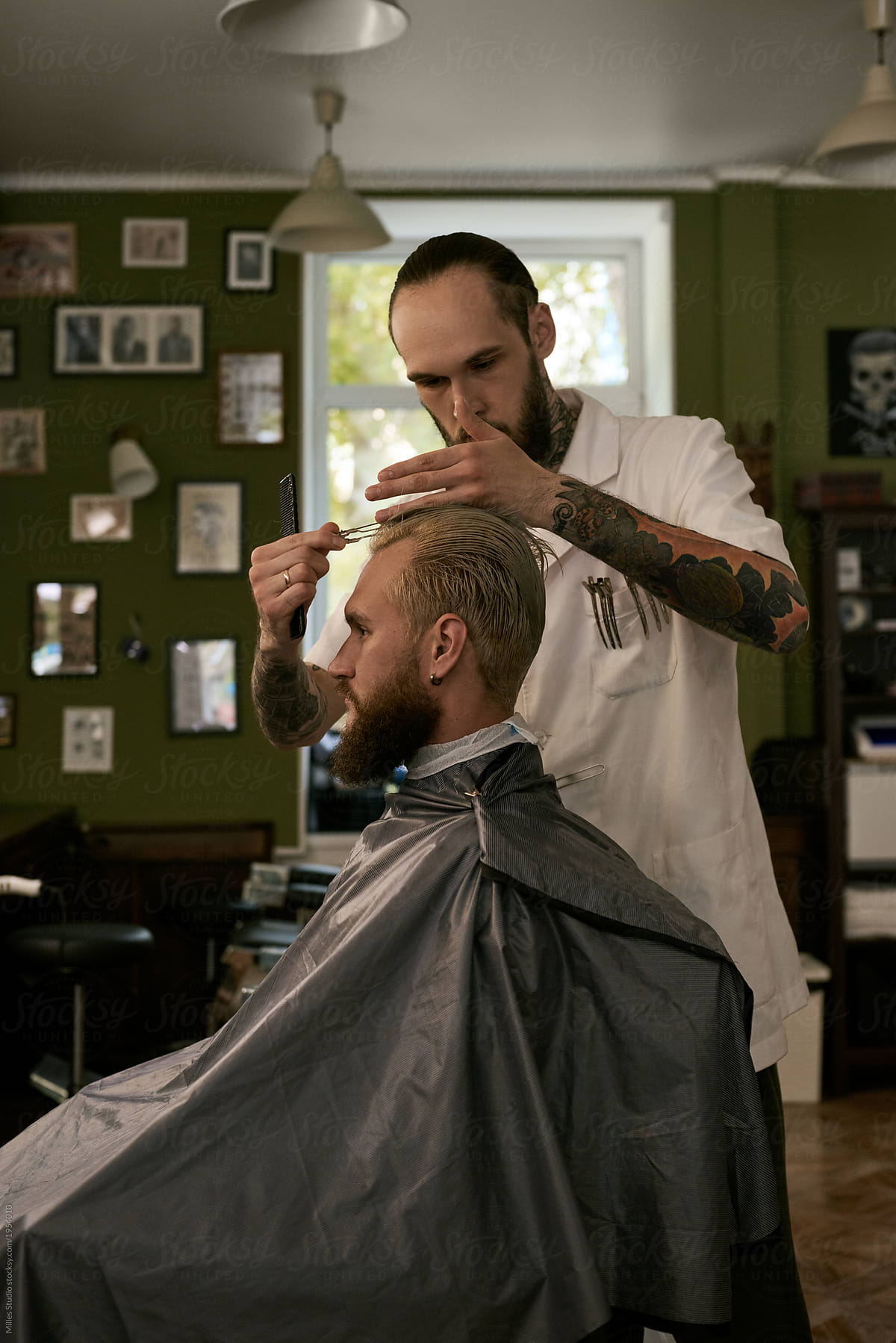 Barber preparing man for haircut