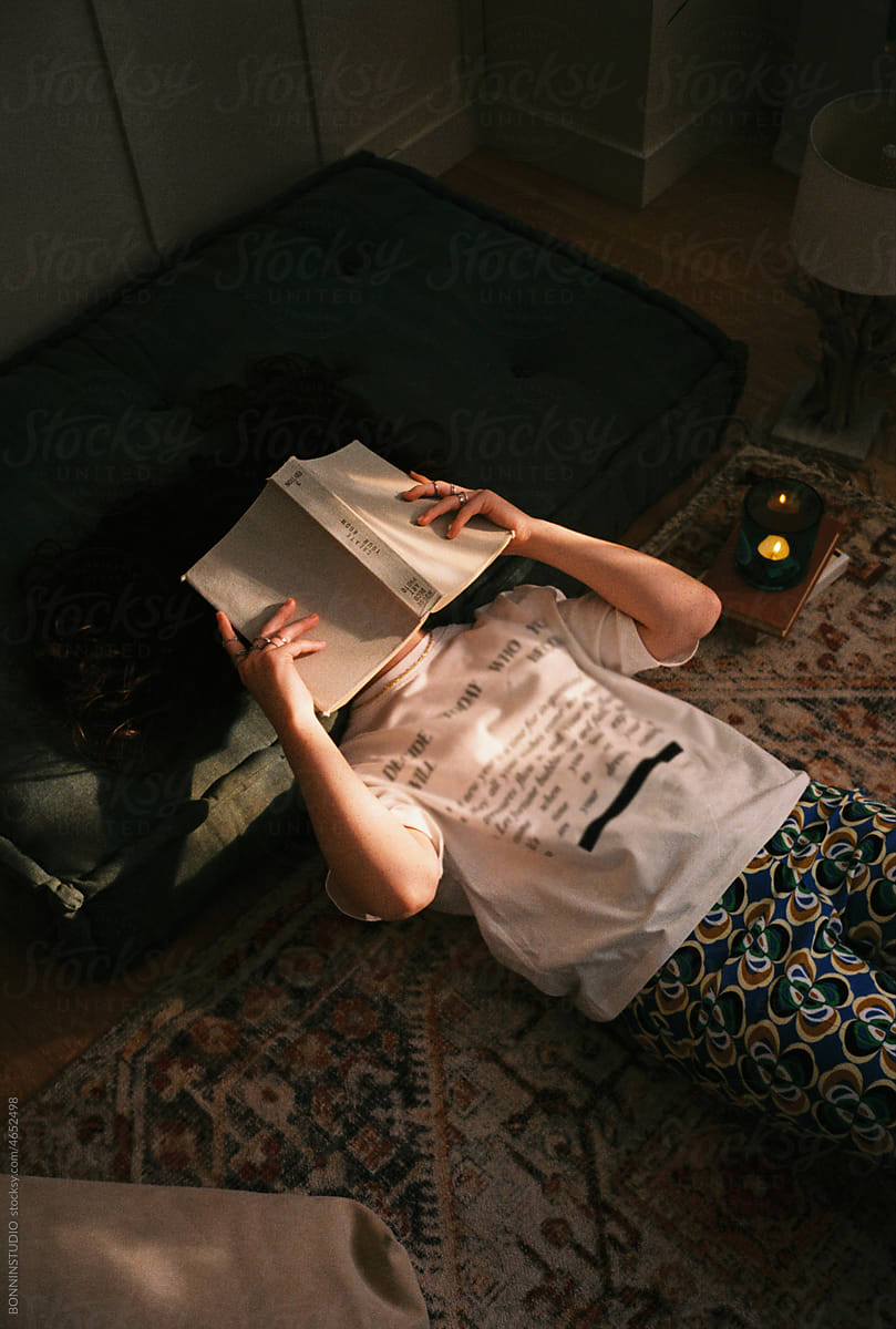 User-generated content teen girl covering her face with book