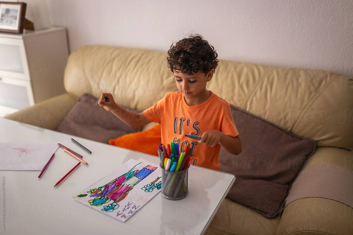 little boy coloring a nice drawing at home