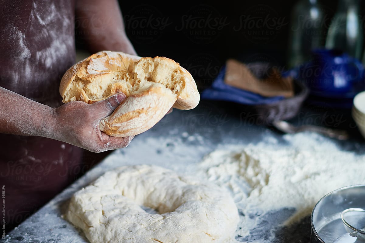 Cook breaking fresh-baked bread