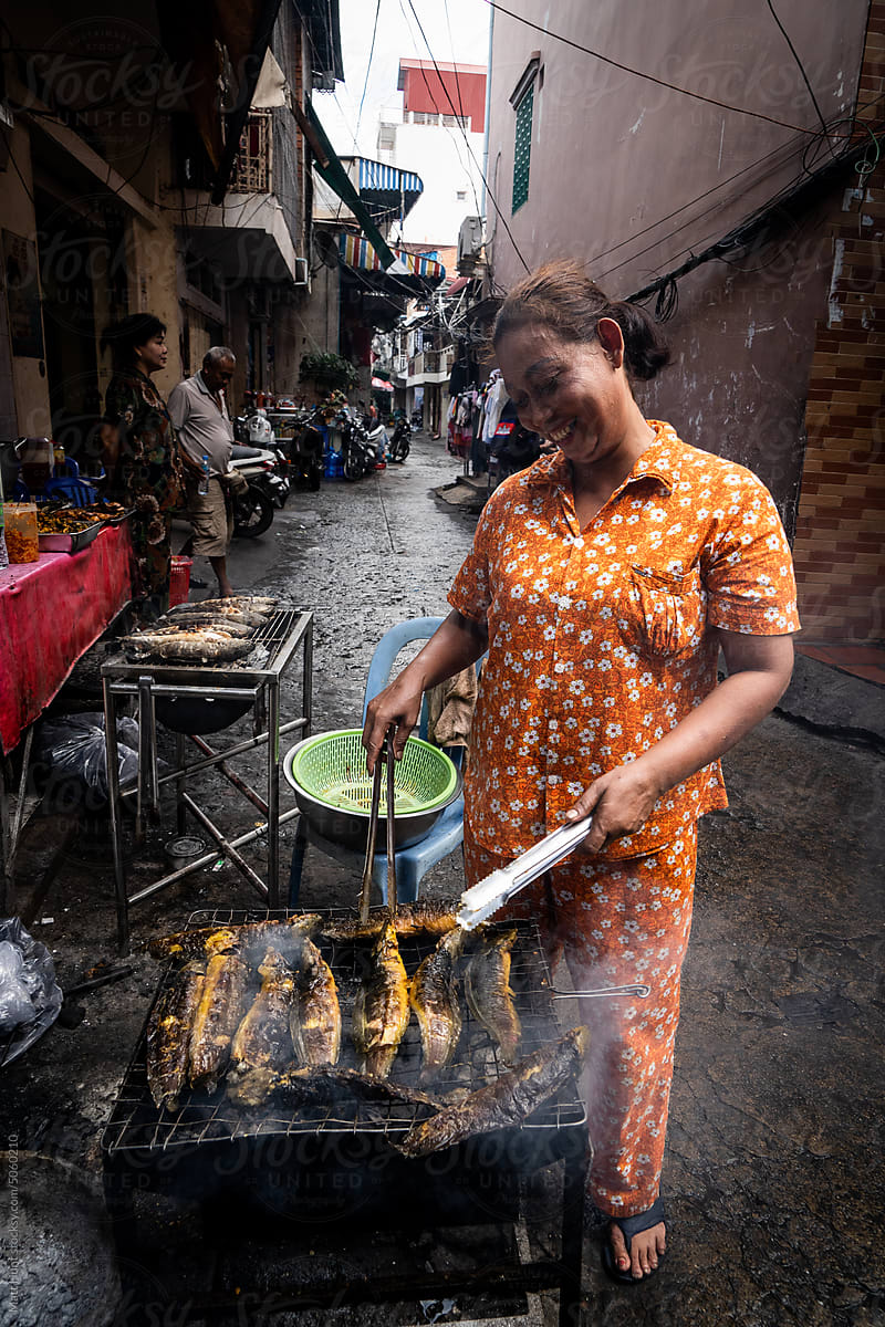 Street food vendor grills Mekong River fish on the street in Cambodia