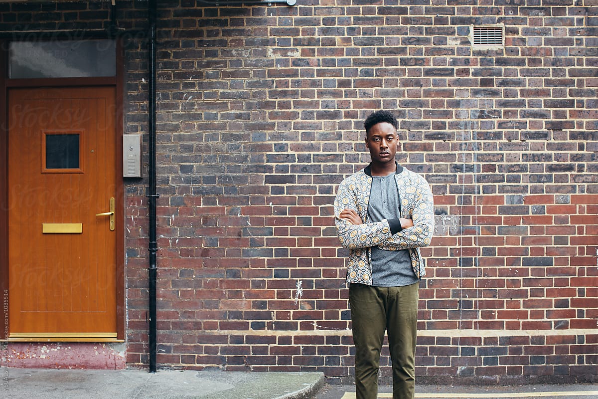 Casual Black Man Standing in Front of Working Class Home