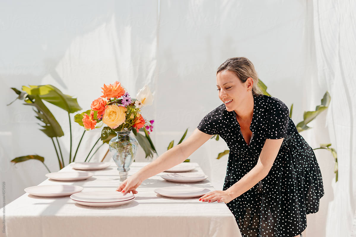 Woman preparing lunch table on terrace