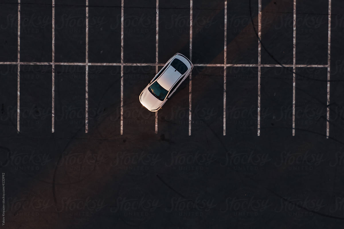 tele shot of a white sedan car on the parking slot