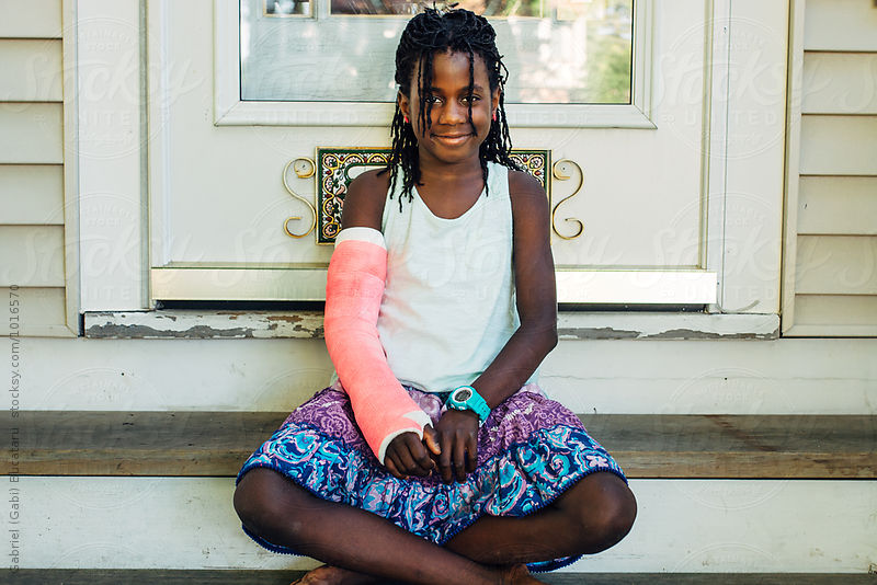 African American girl with pink cast on her broken arm