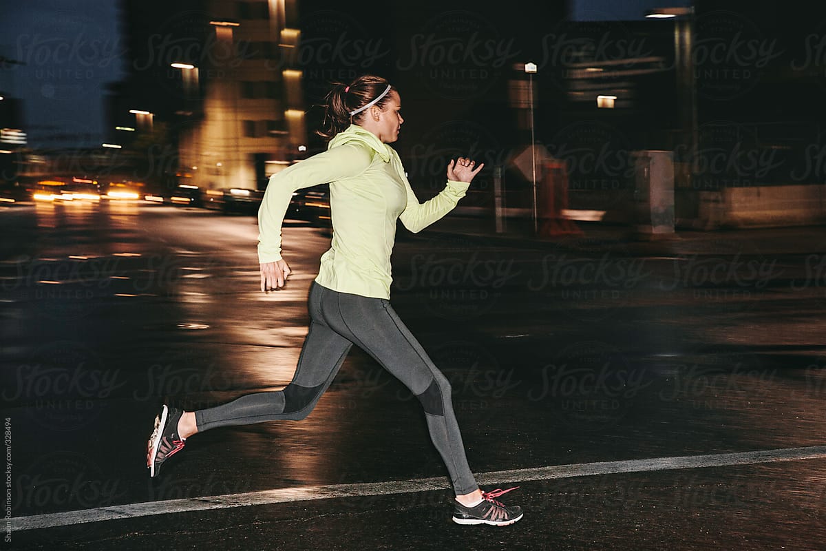 Woman Running Across Street At Night Del Colaborador De Stocksy Shaun Robinson Stocksy