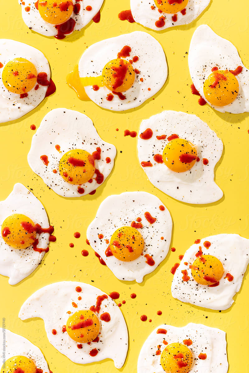 Fried Eggs on Yellow with Cracked Black Pepper and Hot Sauce