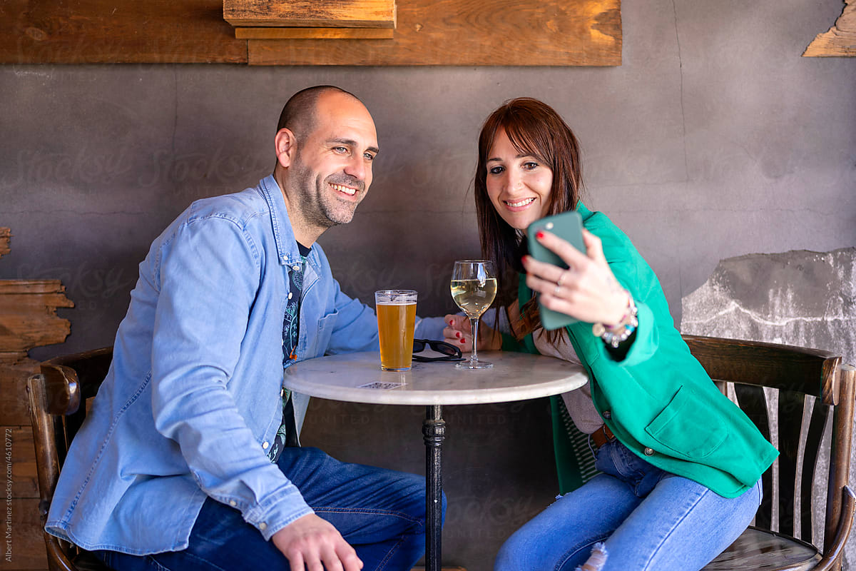 Loving couple taking selfie during date in restaurant