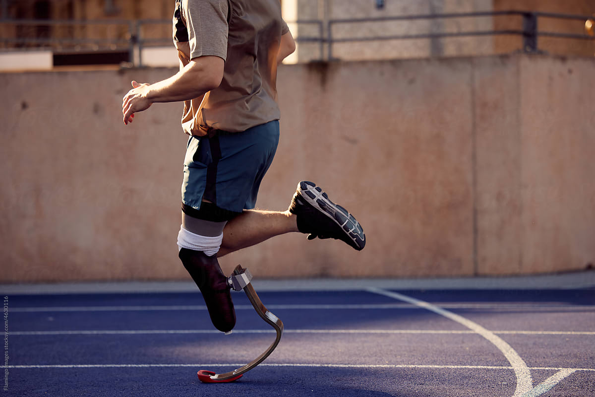 Fit man with a prosthetic blade running on an outdoor track