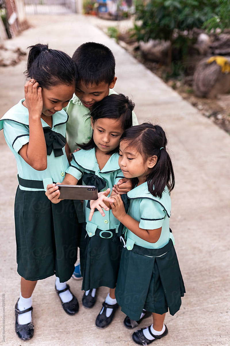 Asian schoolkids using smartphone