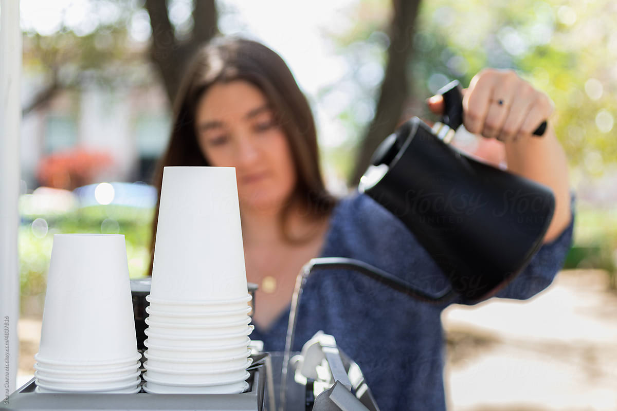 A girl pouring water from a jug to make coffee