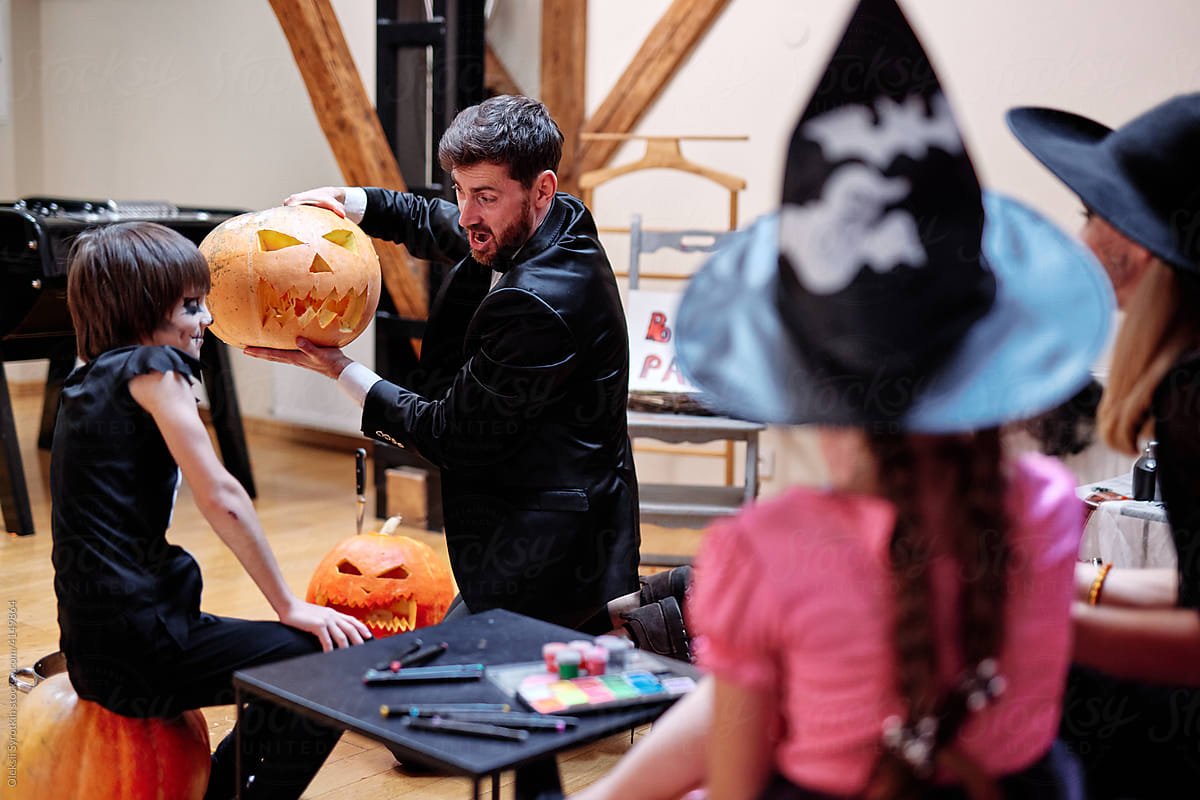 Man playing with carved jack o lantern on Halloween