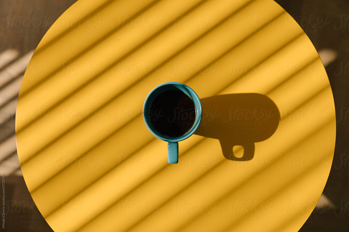 Top view of a coffee cup on a yellow table