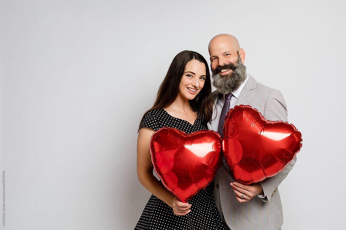Couple Holding Heart Shaped Balloons Del Colaborador De Stocksy