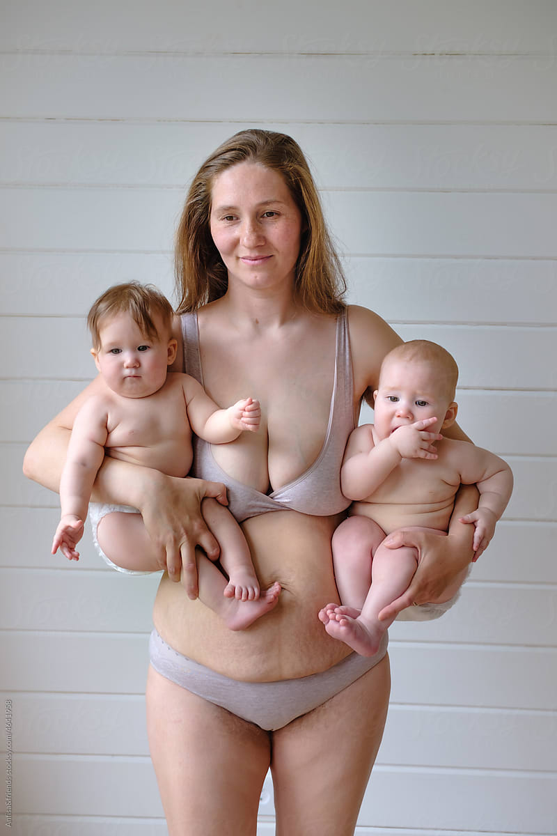 woman in lingerie posing holding two babies