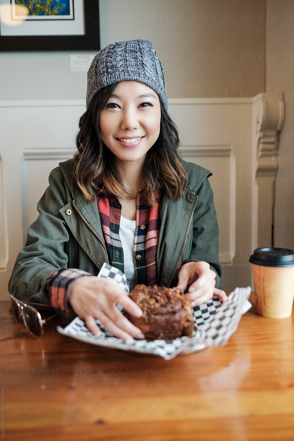 Happy Asian woman eating a cake dessert in a cafe