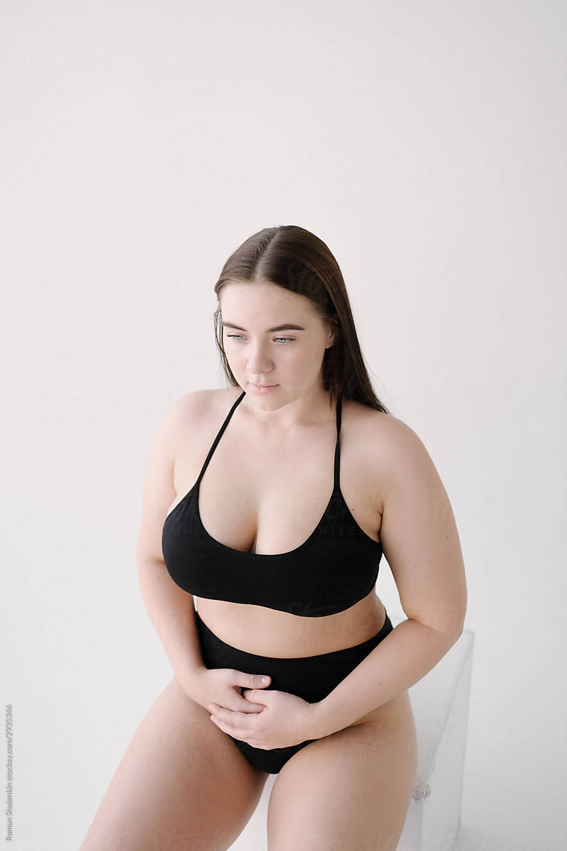 Curvy Model in Black Underwear Sitting on Cube