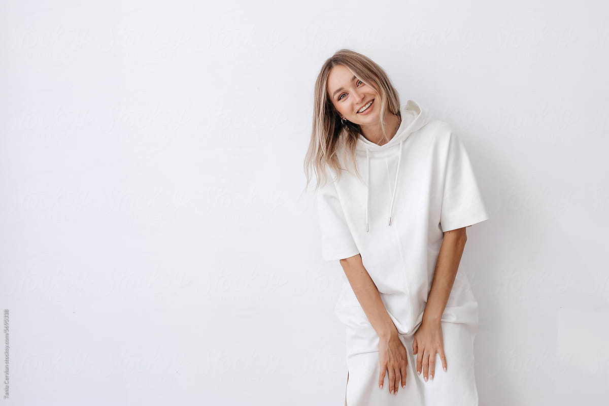 Smiling woman in white long dress in studio
