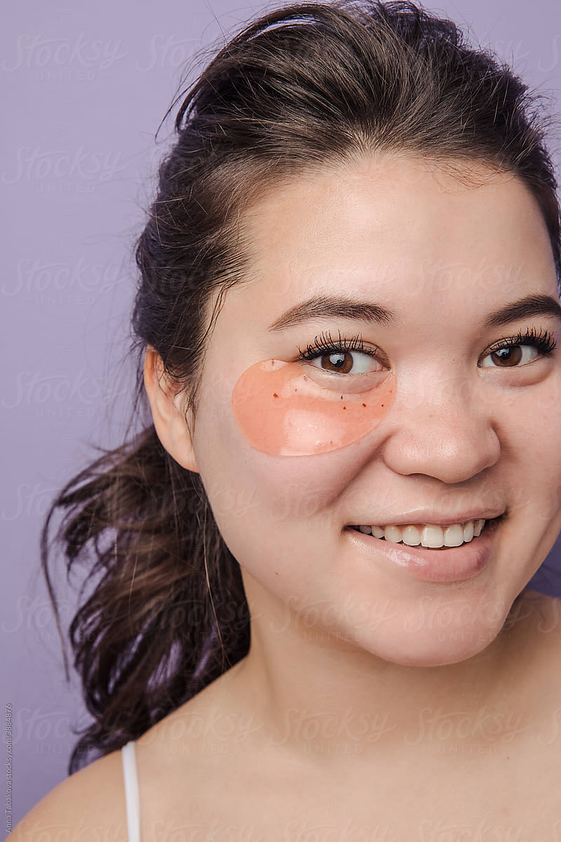 Young brunette east asian woman with skincare under eye patch
