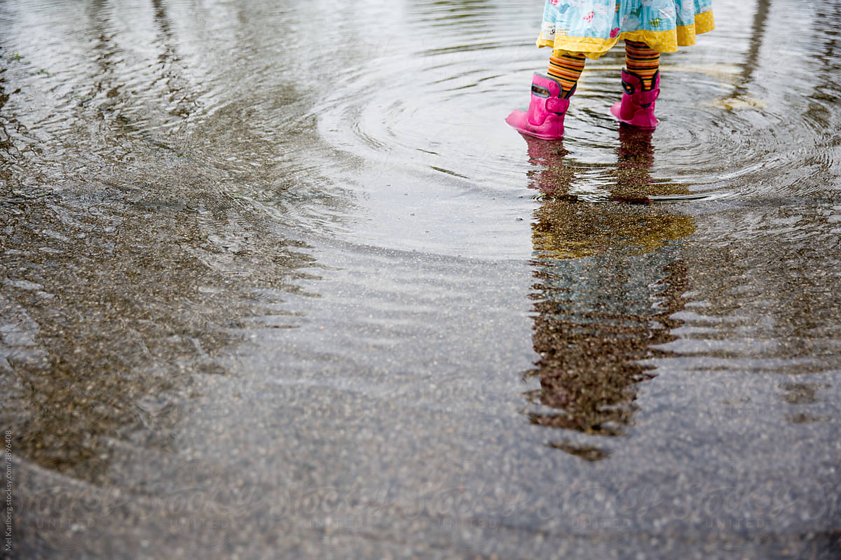 Girl\'s reflection in rain puddle