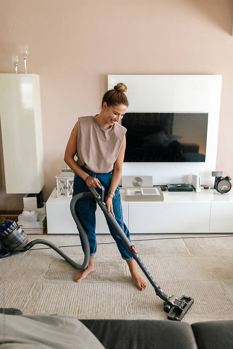 Woman Vacuuming The Carpet