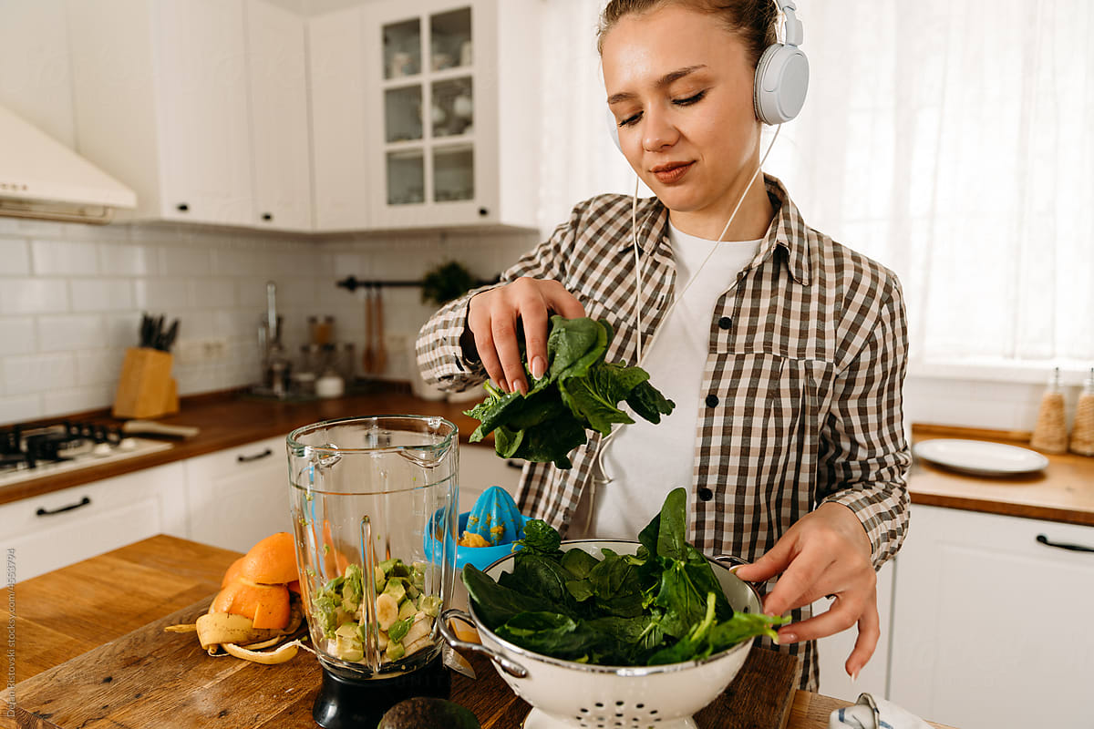 Girl prepare spinach smoothie for breakfast