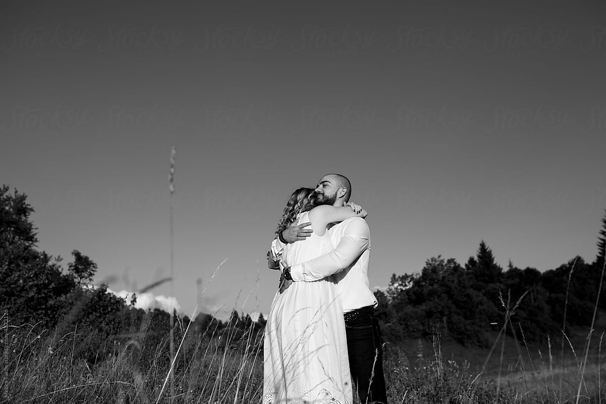 Portrait in black and white shows a happy couple hugging