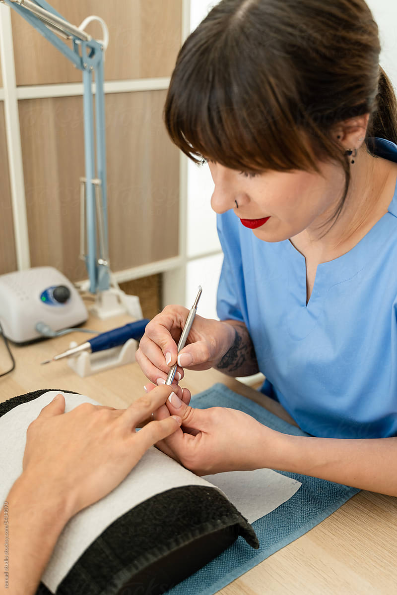 Female manicurist painting a client\'s nails.