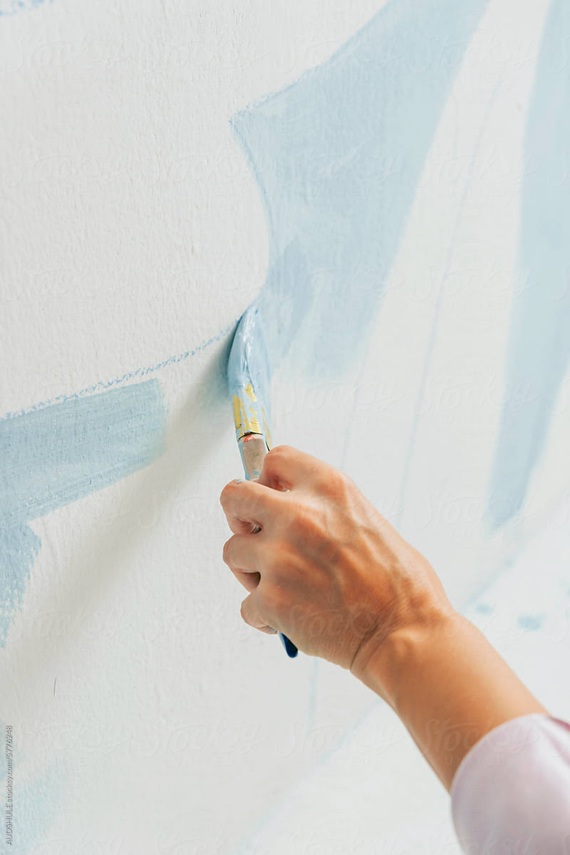 artist hand painting wall