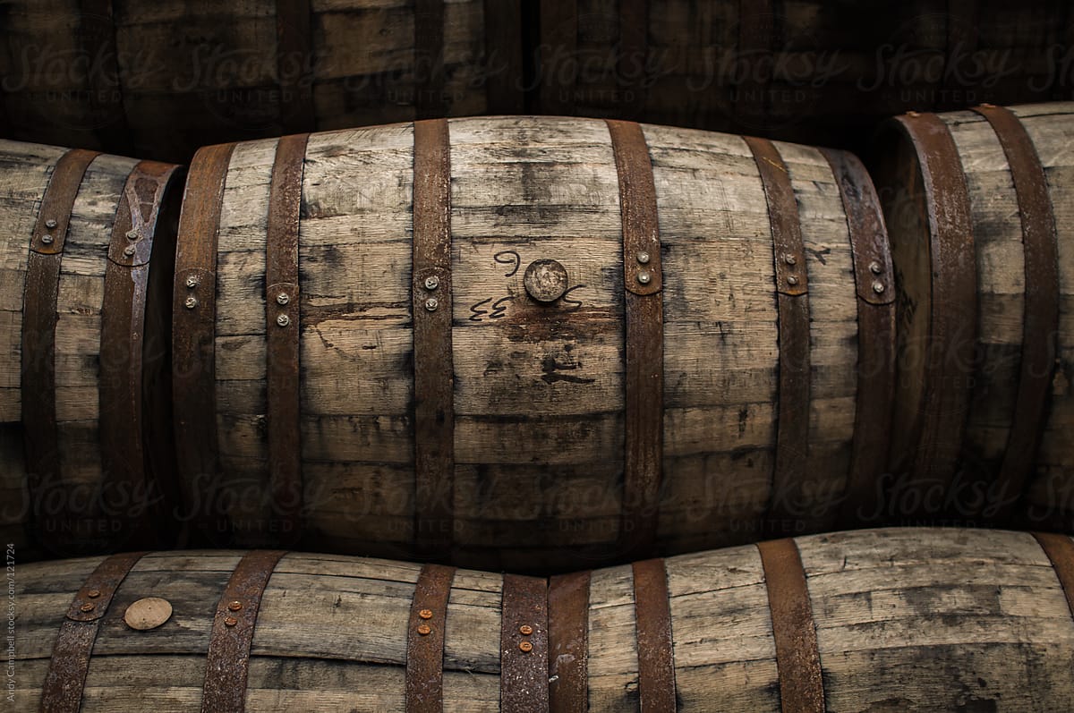 Wooden barrels and casks sit in a pile