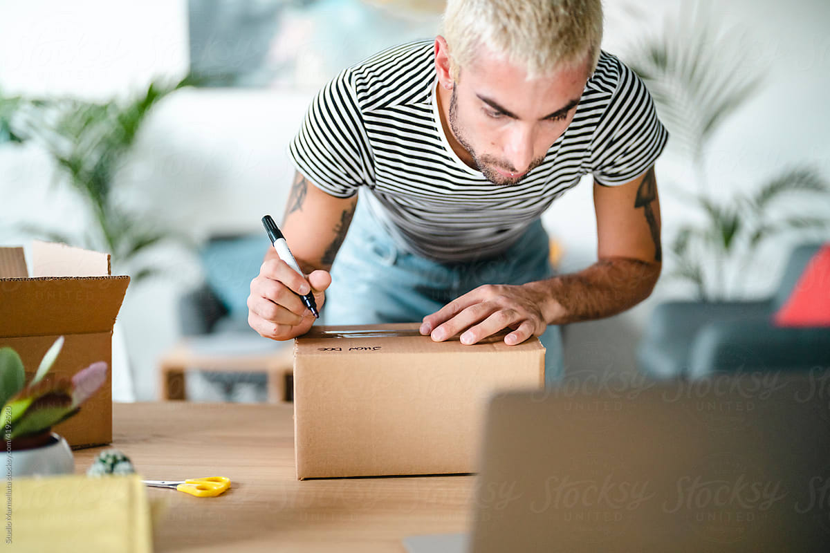 Male seller writing address on box