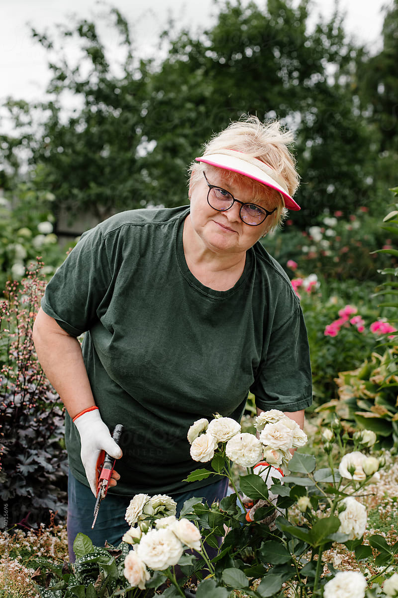 an elderly woman works in the garden