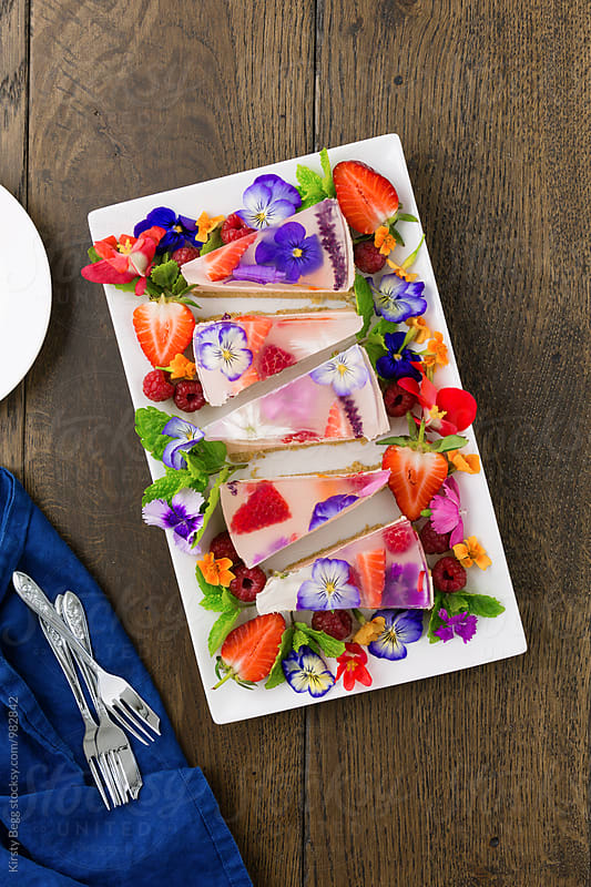 Wedges of jelly slice with edible flowers and berries