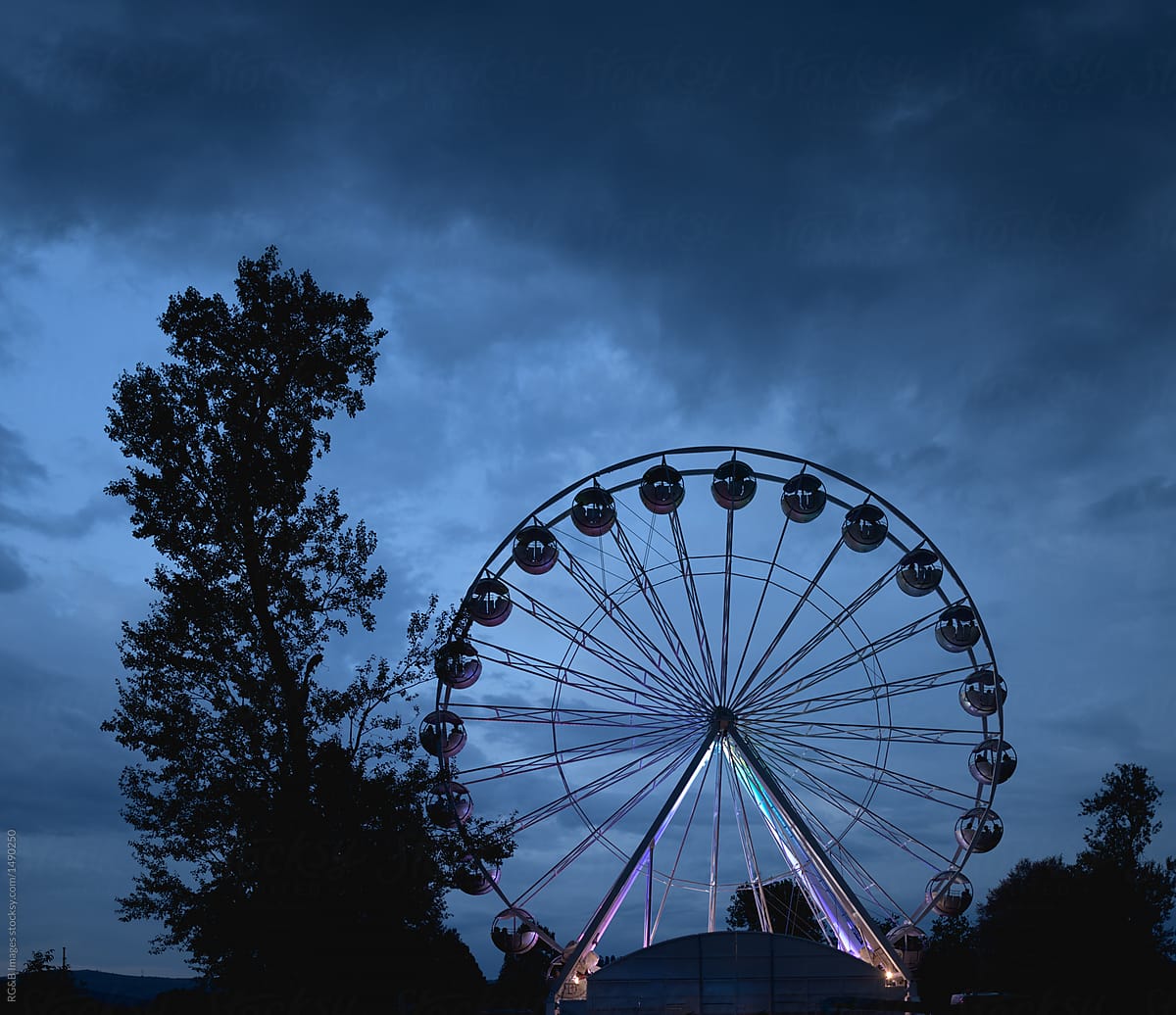 Ferris wheel silhouette on overcast moody sky background