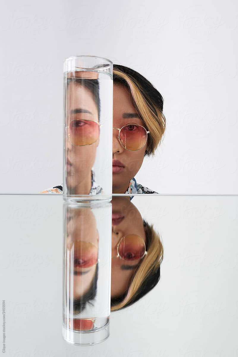 Modern woman in sunglasses through contorted glass