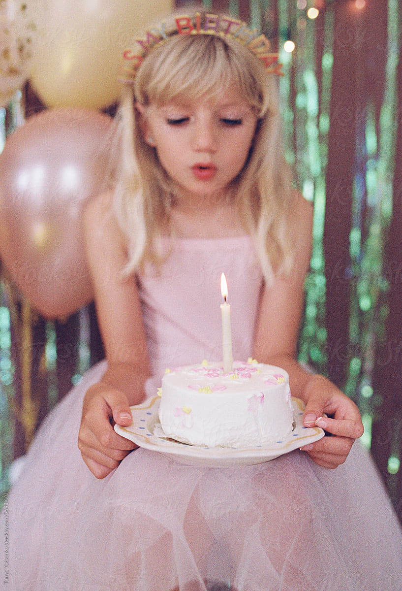 A birthday girl holding a cake.