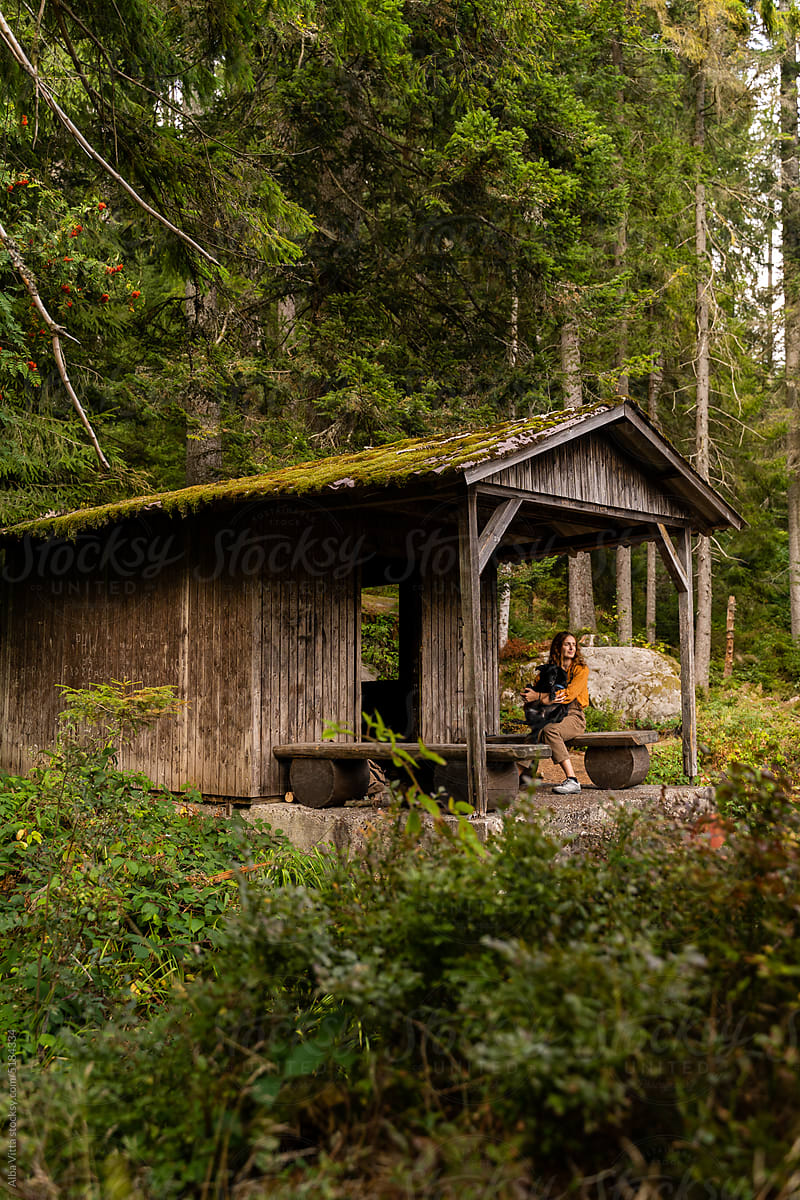 woman in wooden cabin in forest