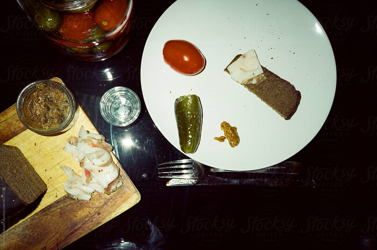 Slavic set of appetisers with salo, bread, pickled cucumber, vodka