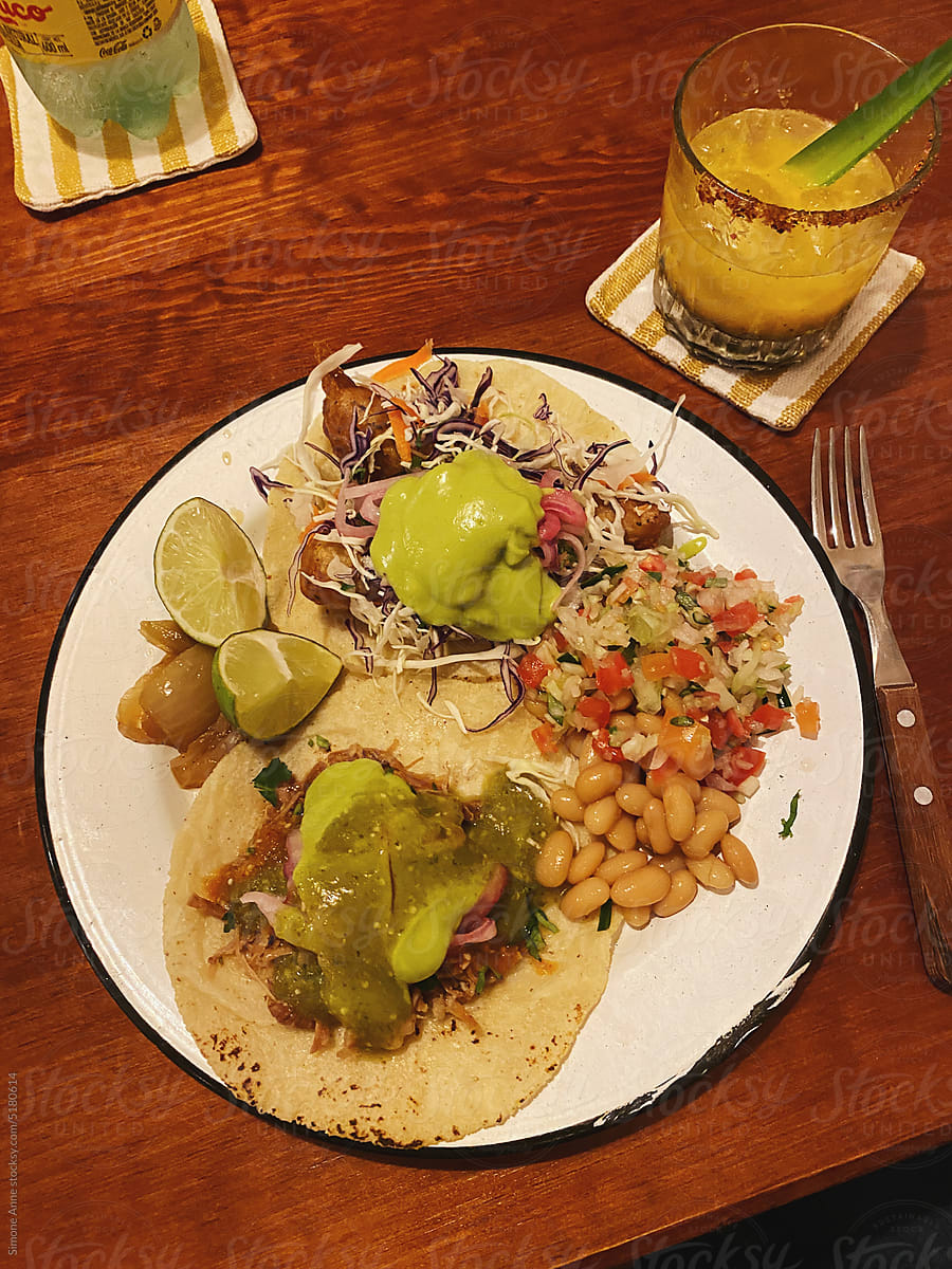 Fish tacos on a plate with passionfruit margarita