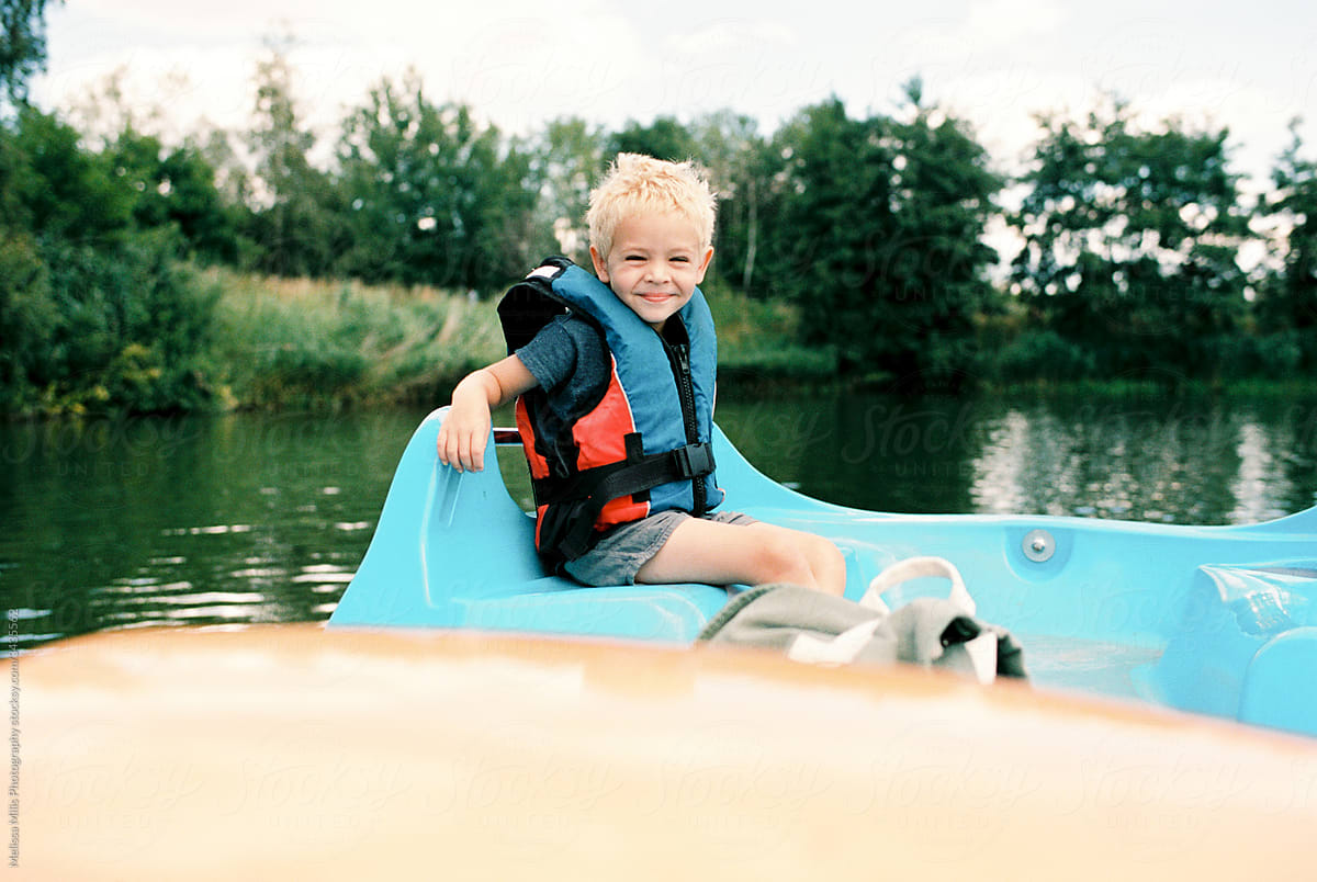 Toddler boy with life jacket in a pedalo boat