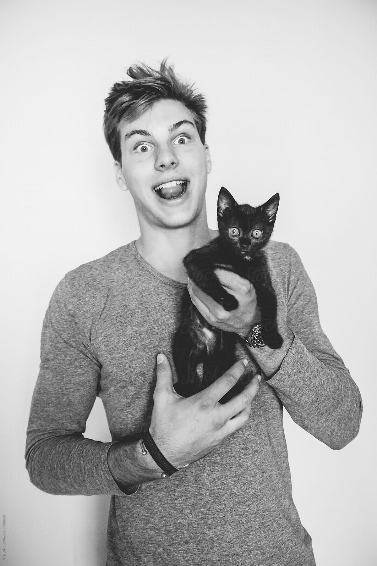 Young man with a black kitten