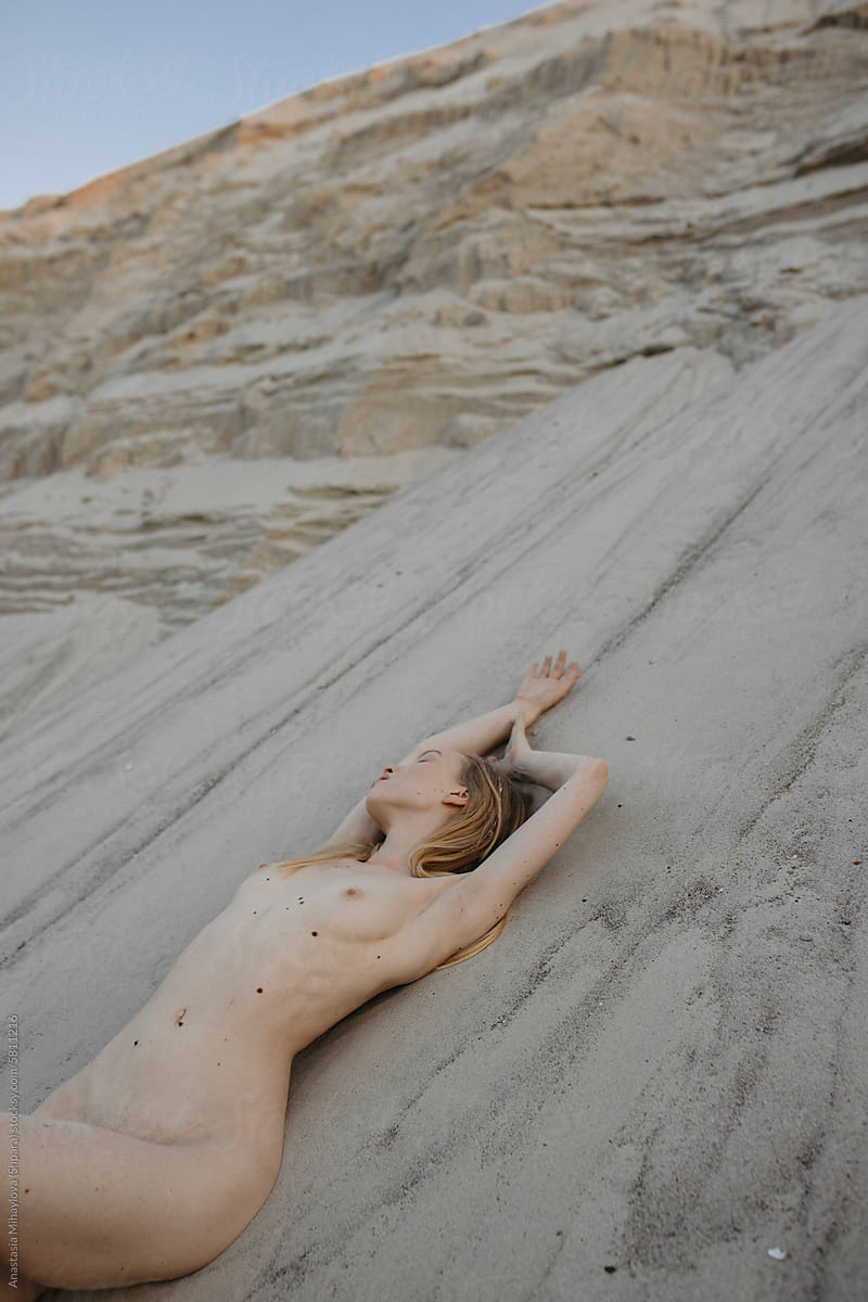Naked natural blonde woman in nature on the sand