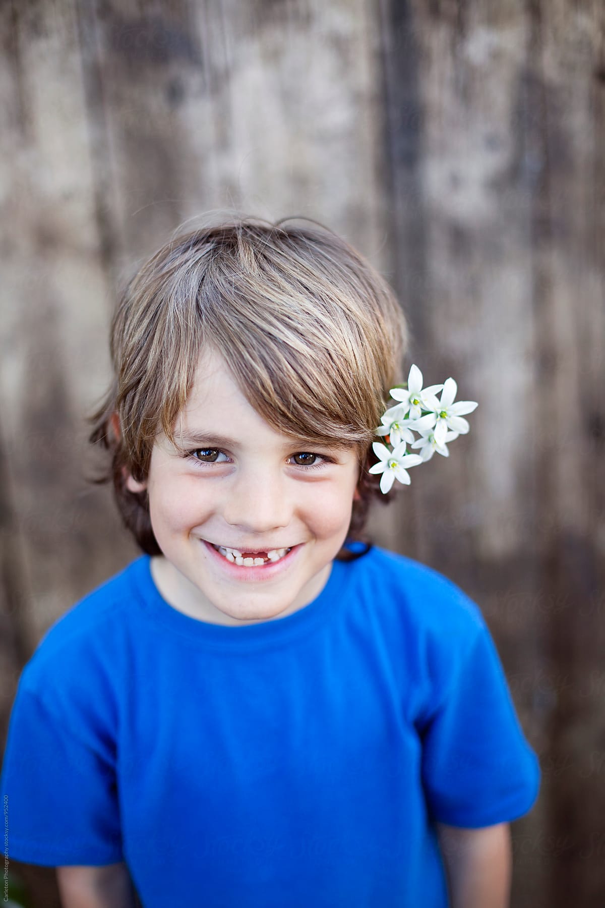 Headshot Of Smiling Seven Year Old Boy With Flowers In His Hair