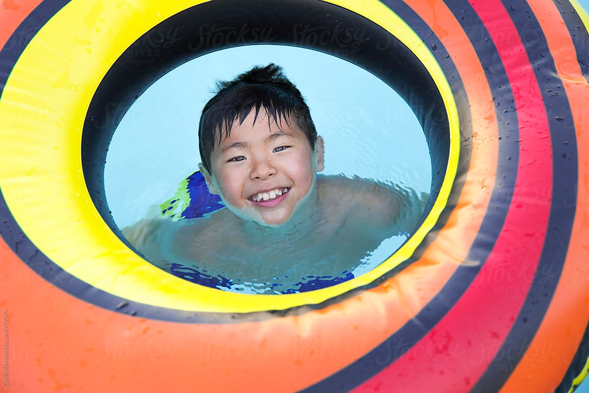 Young asian boy playing with inner tube