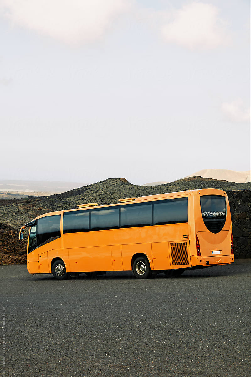 Yellow mustard bus in a volcanic landscape