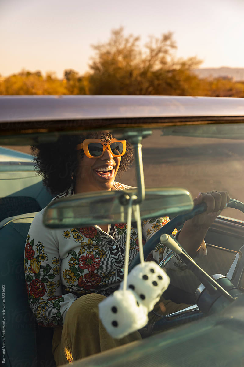 Beautiful African American woman in Vintage Car with fuzzy dice