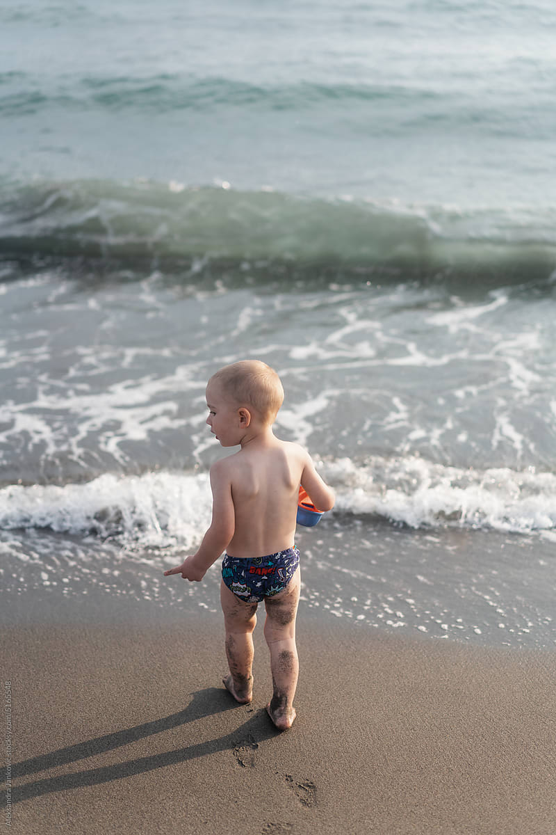 Child In The Swimming Pants Walking On The Beach