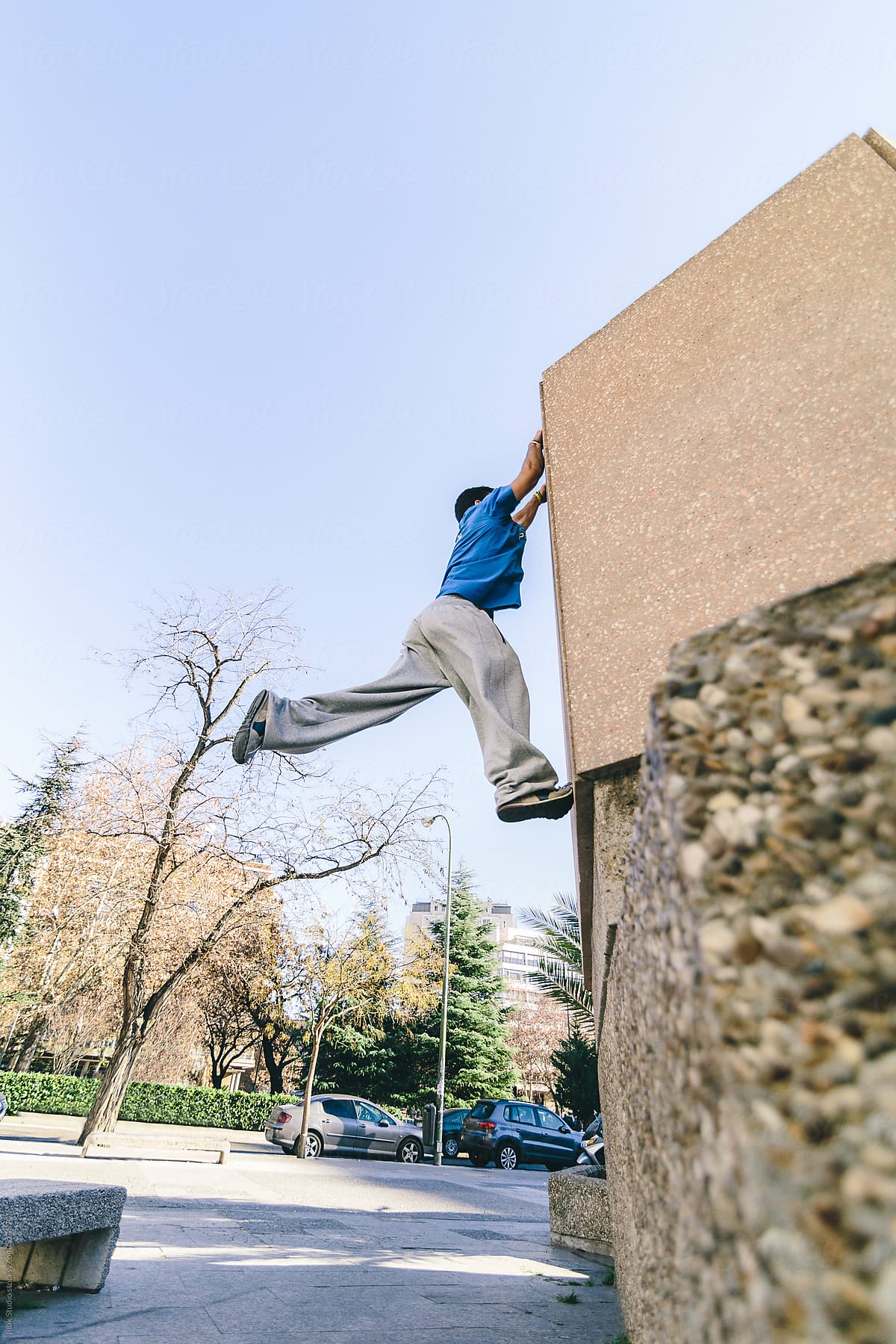 Man jumping and clutching during a parkour training in a city